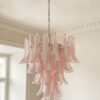 Pink Murano petal chandelier hanging from an ornate ceiling rose in a Stockholm apartment