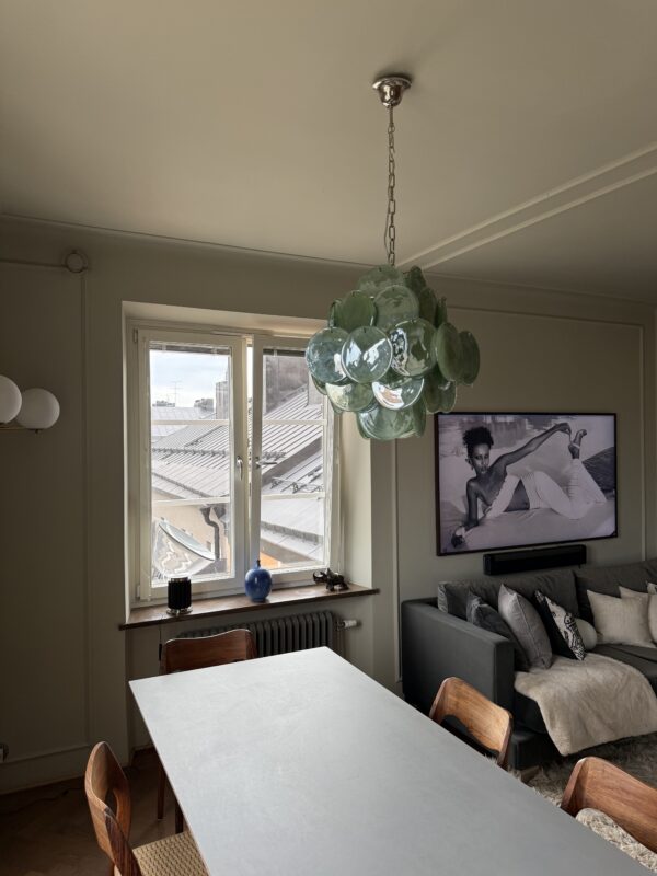 Green Murano disks chandelier above a dining table