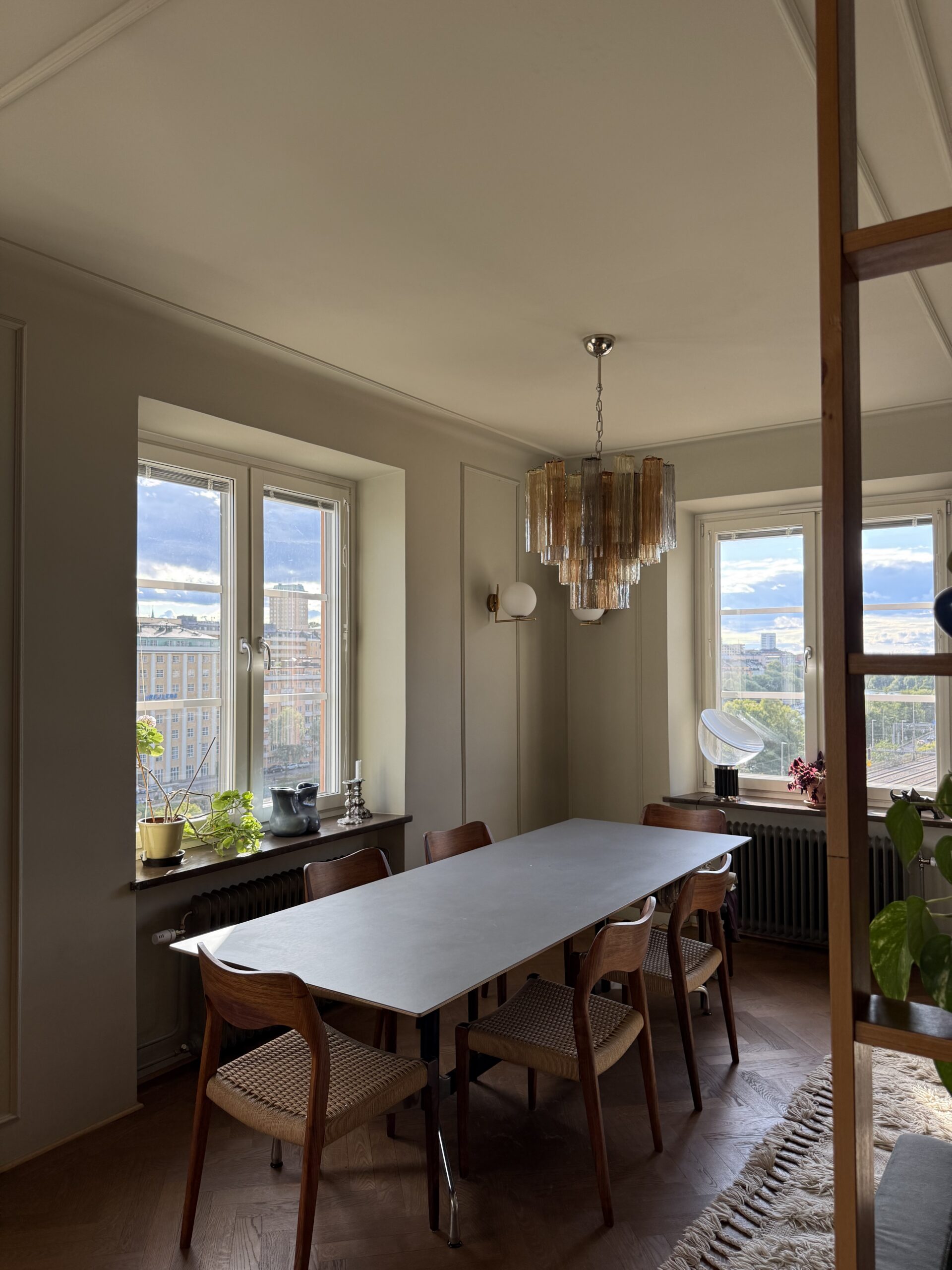 Multicolour Murano tubular chandelier above a dining table by the window